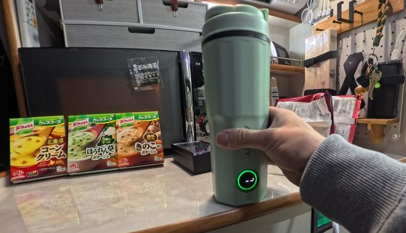 手のひらサイズの電気ケトルを使いお湯を沸かしている人